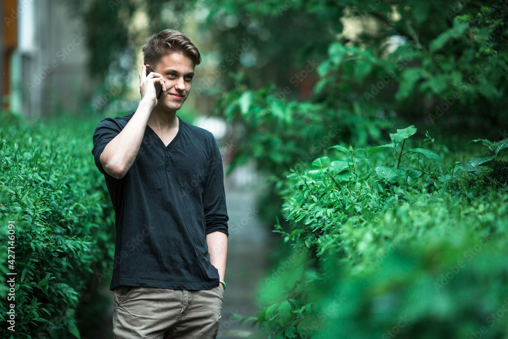 Charming young man talking on mobile phone outdoors. Charming young man talking on mobile phone outdoors.