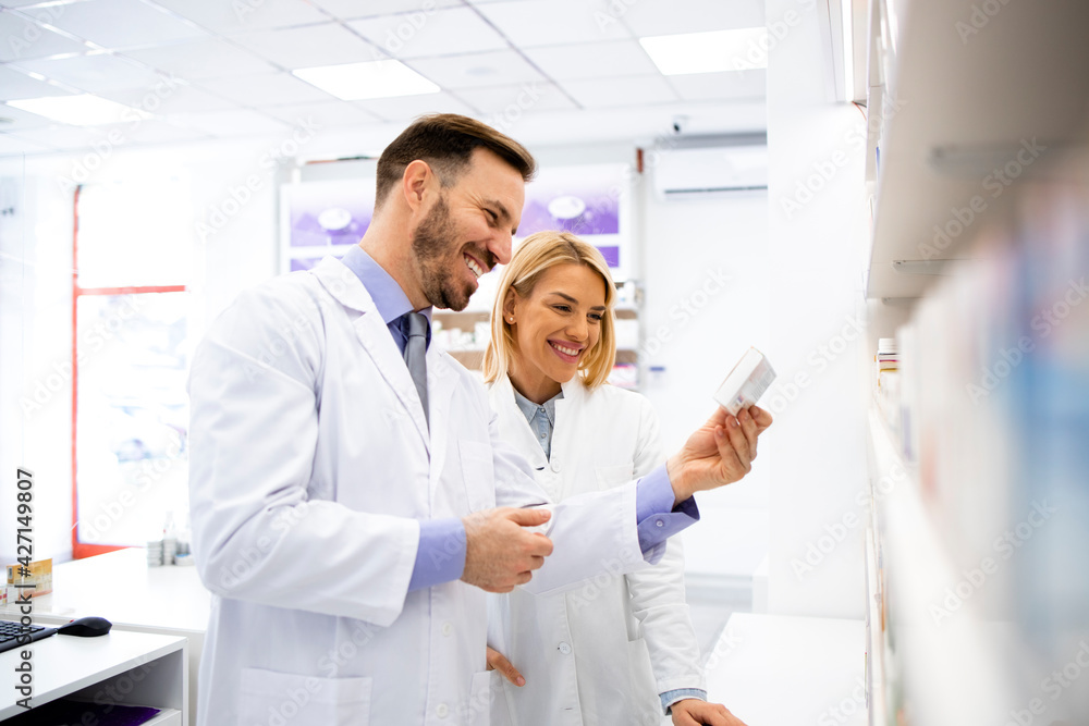 Obraz premium Pharmacists talking about new medicines in pharmacy store and working together.