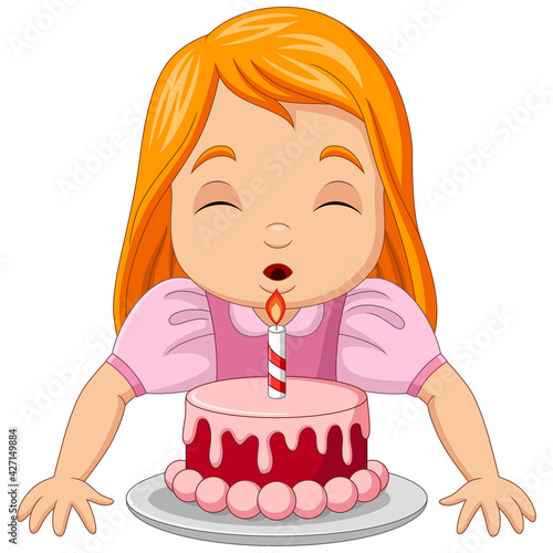 Happy girl blowing candles of birthday cake