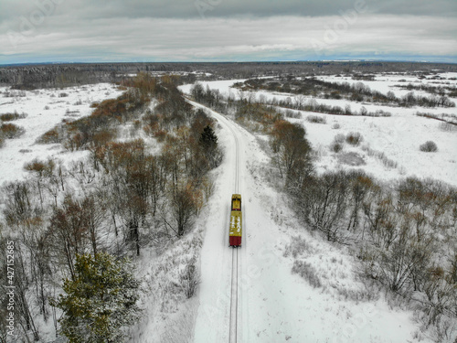 Aerial view of a moving small train that travels on a narrow gauge railway in winter (Kirovo-Chepetsk, Kirov region, Russia) photo