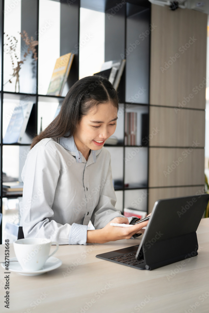 Portrait go happy female employee smiling and working on computer tablet at modern office. Portrait go happy female employee smiling and working on computer tablet at modern office.