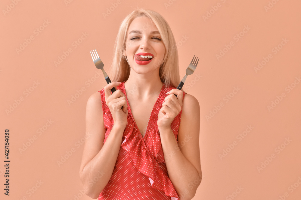 Obraz premium Beautiful young woman with forks on color background