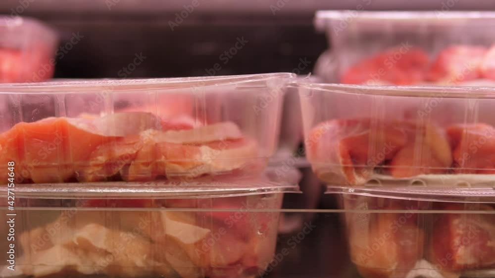 Close up raw red meat in plastic boxes showcased in a butcher shop Close up raw red meat in plastic boxes showcased in a butcher shop