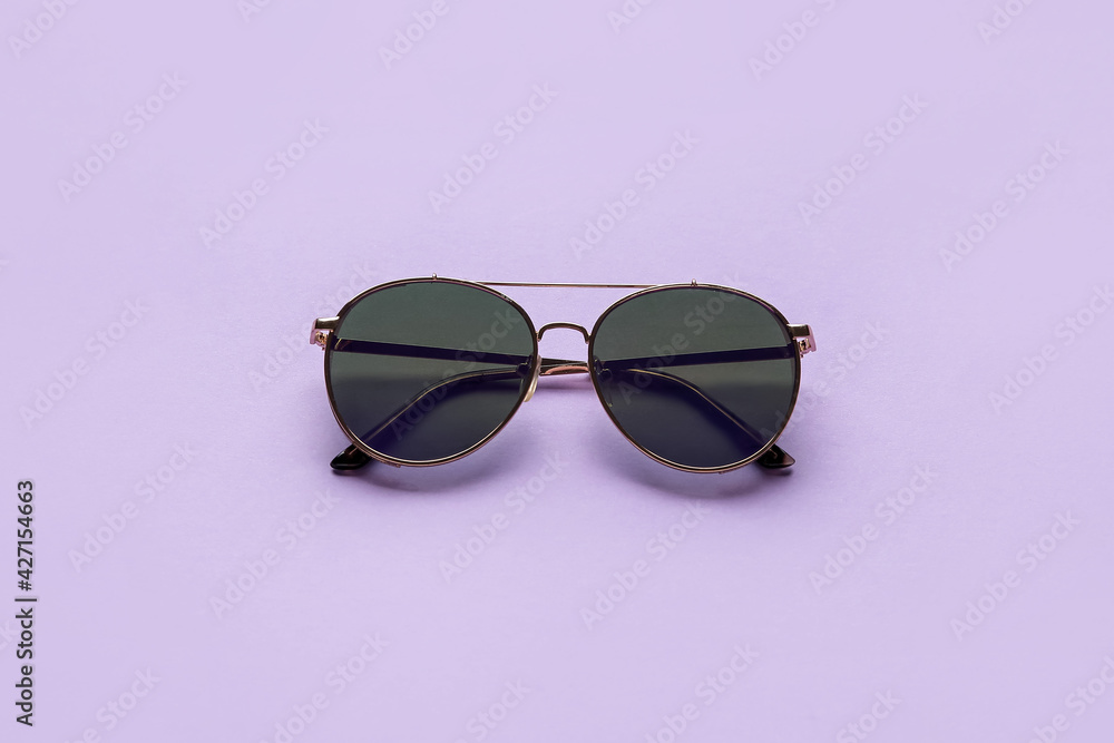 Stylish sunglasses on color background