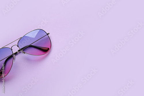 Stylish sunglasses on color background