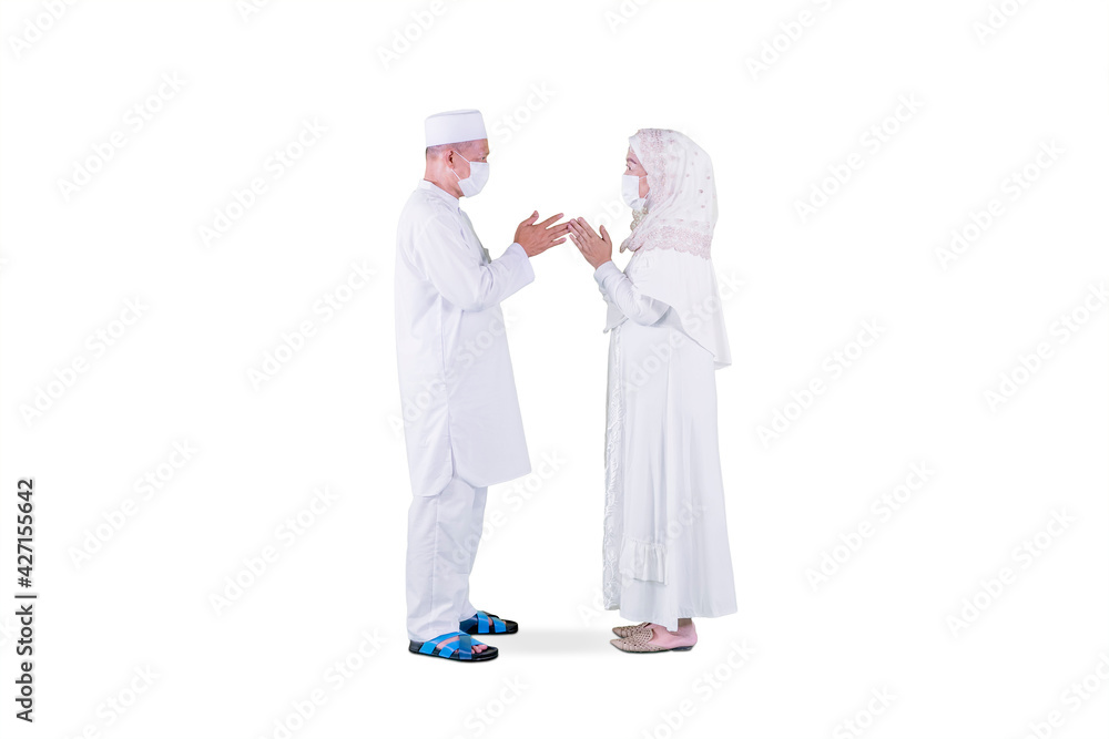 Muslim old couple in mask apologizing each other Muslim old couple in mask apologizing each other