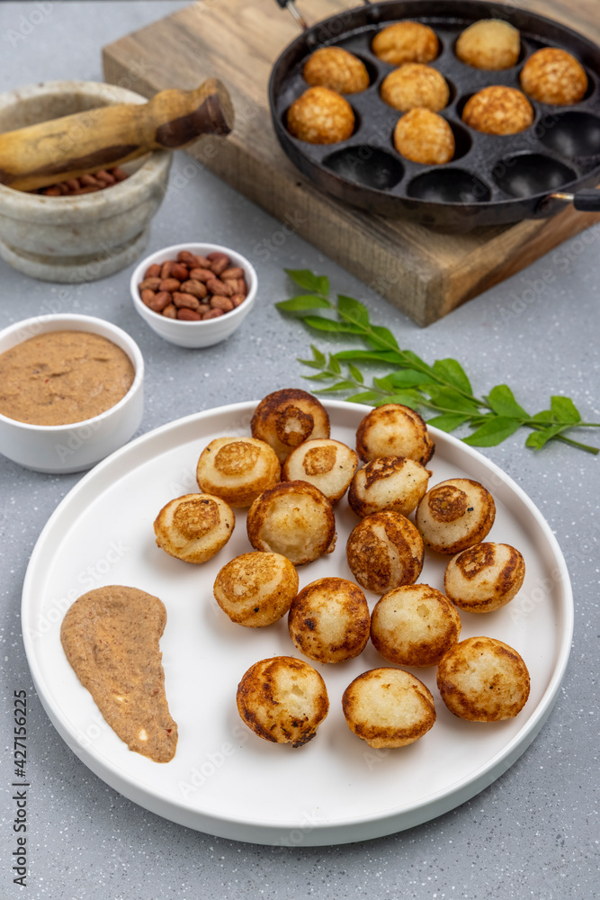 Suji appe or appam served on a appam pan with peanuts and tamarind chutney Suji appe or appam served on a appam pan with peanuts and tamarind chutney