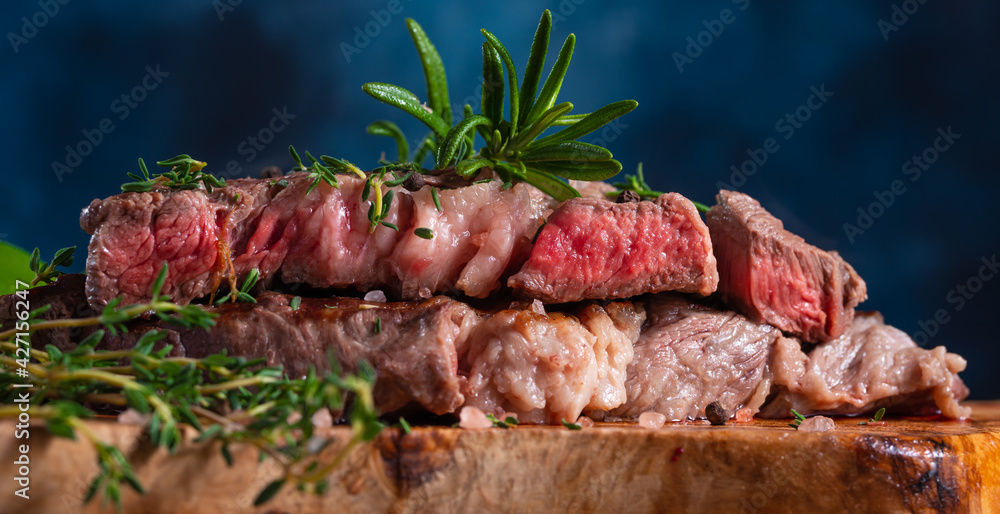 Medium cooked steak with rosemary close-up. Meat recipes and illustrations for meat recipes, recipe book Medium cooked steak with rosemary close-up. Meat recipes and illustrations for meat recipes, recipe book