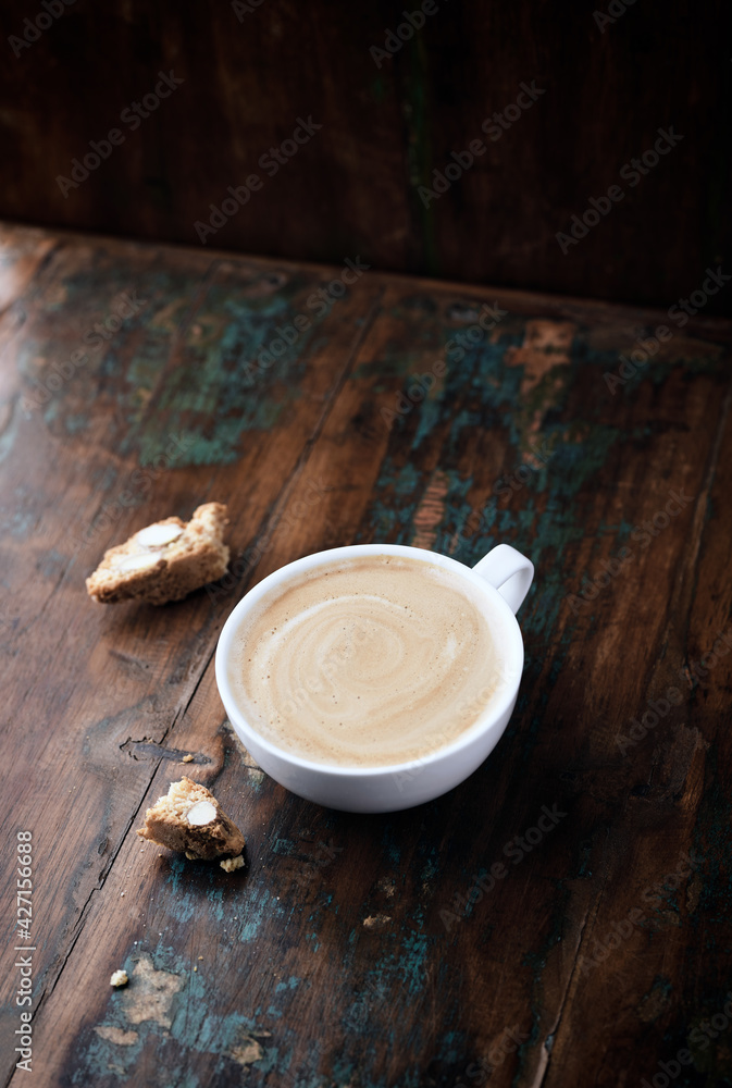 Cappuccino and Cantuccini (Italian cookie) on dark wooden background. Copy space. Cappuccino and Cantuccini (Italian cookie) on dark wooden background. Copy space.