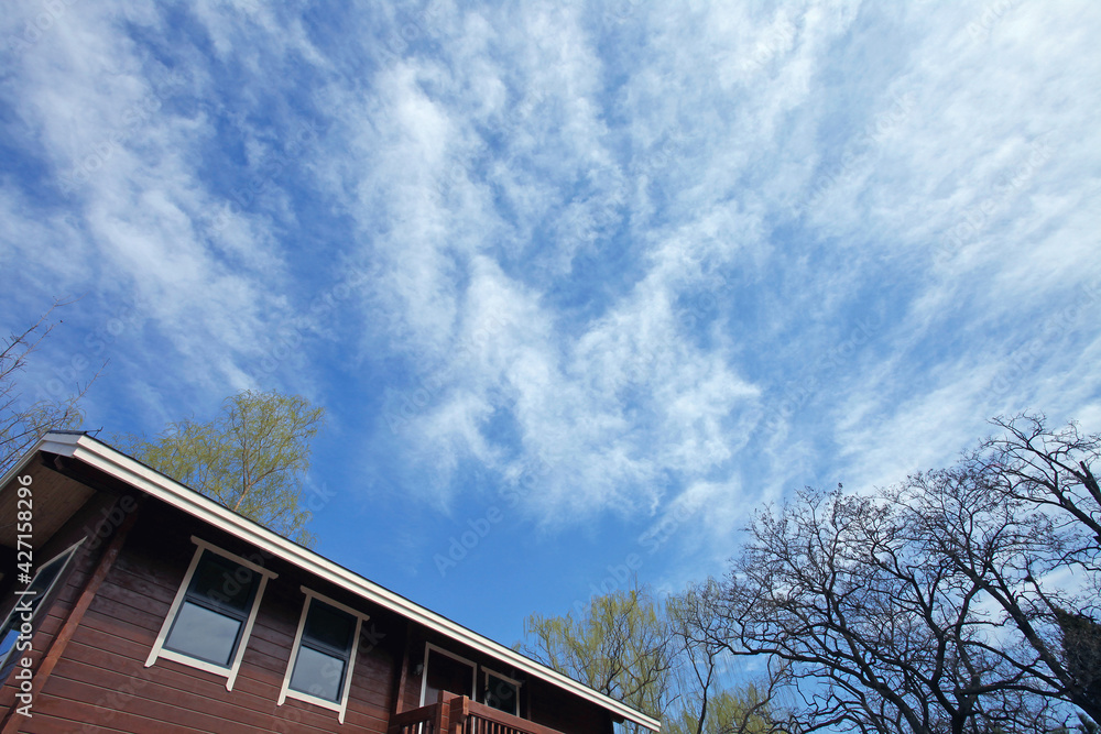 Blue sky and white clouds over the wooden house