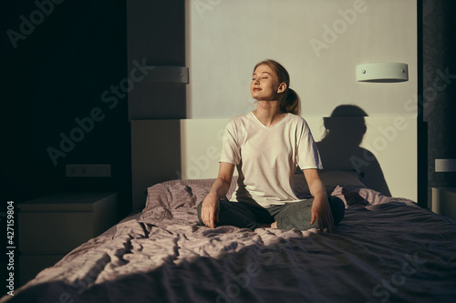 Young caucasian female in bed at the morning is relaxing