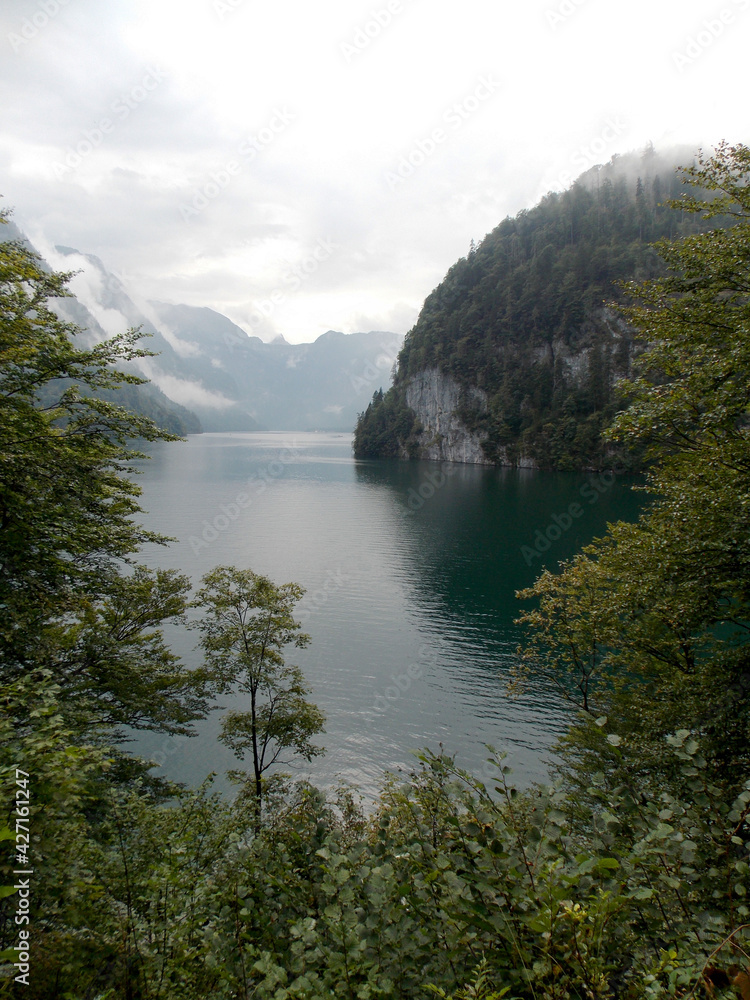 Nice view between trees on mountains and lake in Berchtesgaden in summer