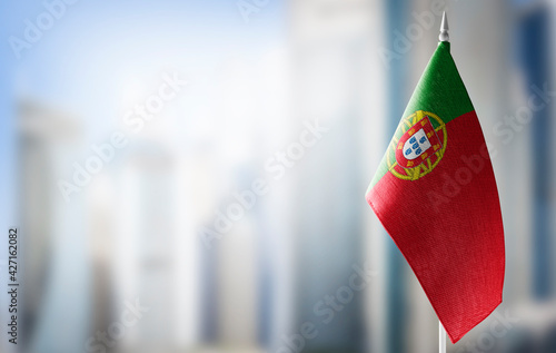 A small flag of Portugal on the background of a blurred background
