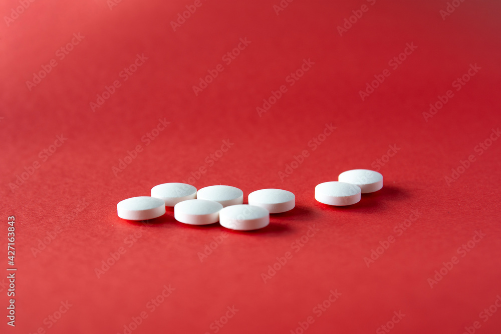selective focus pills. white pills on the red ground selective focus pills. white pills on the red ground