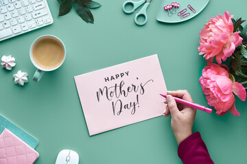 Mothers day greeting card design. Text Happy Mother's day. ink peony flowers on faded mint green background with paper confetti. Coffee, keyboard, flowers, sweets. Trendy casual top view.
