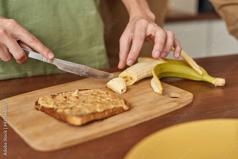 Young same sex male couple cutting banana on toast