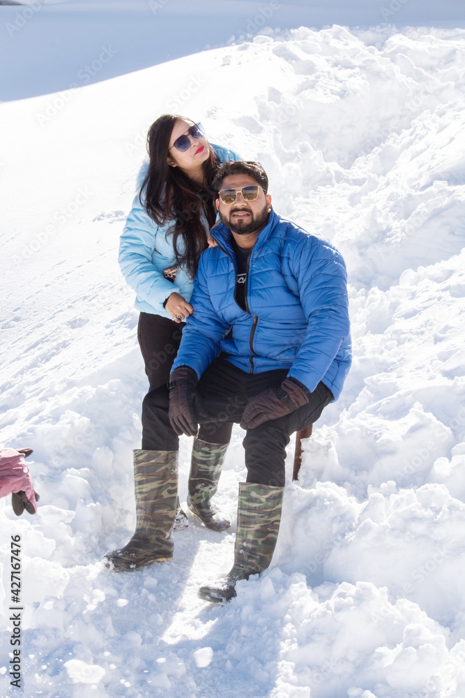 Couple in warm clothing spending leisure time on snow during winter vacations