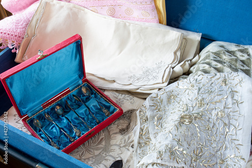 Old fashioned Turkish style dowry in a blue dowry chest. antique spoons, plates, embroidered towels, embroidered muslin and lace. Selective Focus Lace and spoons. photo