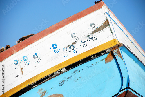 Hands over boat of migrants. Lampedusa, summer 2009.