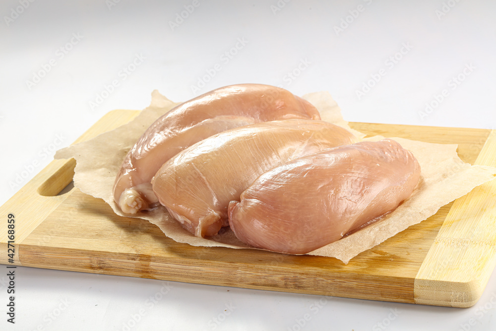 Raw chicken breast fillet over board Raw chicken breast fillet over board