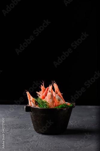 Grilled shrimps . Seafood, shelfish. Shrimps Prawns with spices and fresh herbs on stone black background.