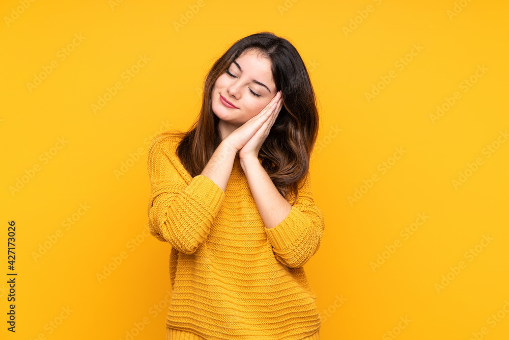 Young caucasian woman isolated on yellow background making sleep gesture in dorable expression Young caucasian woman isolated on yellow background making sleep gesture in dorable expression