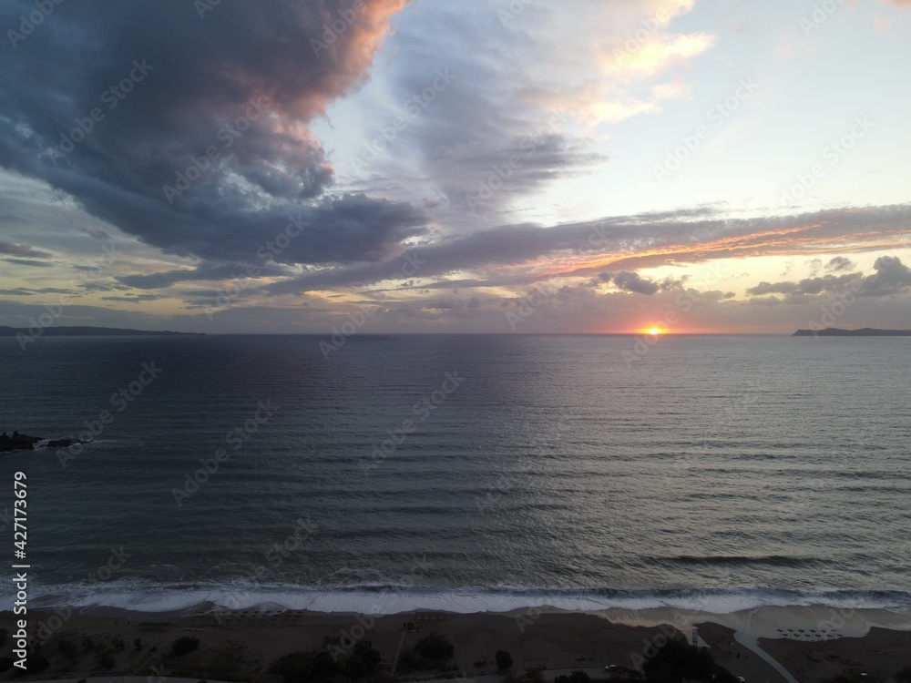 colorful sunset sky and horizon and clouds, in karavostasi beach of perdika in epirus, greece