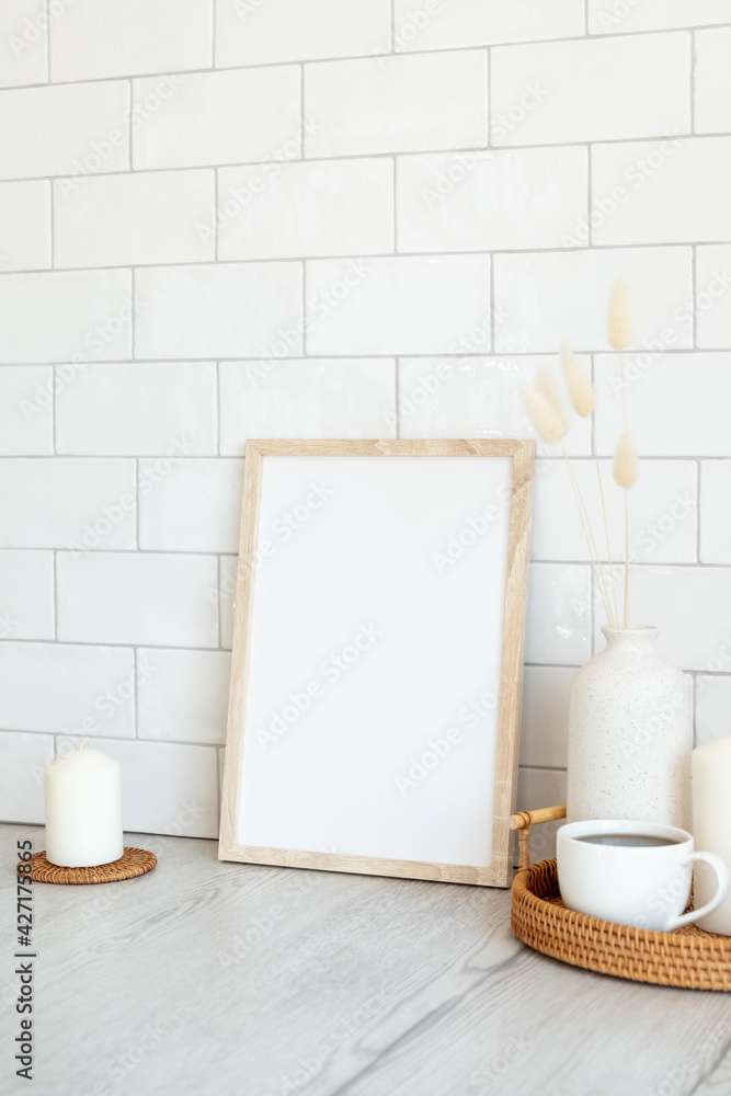 Breakfast still life. Picture frame mockup, tray of hot drink, vase of dried flowers, candles. Brick tiles wall on background. Nordic, Scandinavian home interior.