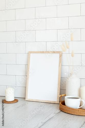 Breakfast still life. Picture frame mockup, tray of hot drink, vase of dried flowers, candles. Brick tiles wall on background. Nordic, Scandinavian home interior.