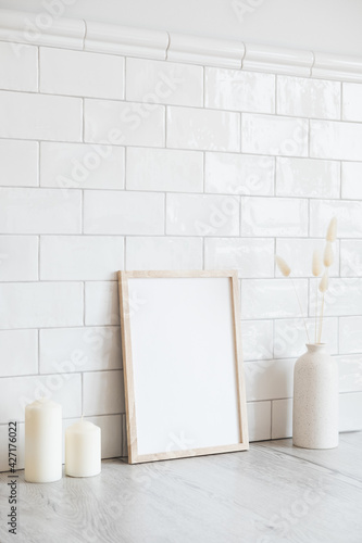 Scandinavian room interior with mockup photo frame  candles  vase of dried flowers. Brick tiles wall on background. Scandinavian  nordic style.