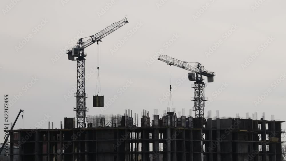 Silhouettes of construction cranes working Silhouettes of construction cranes working