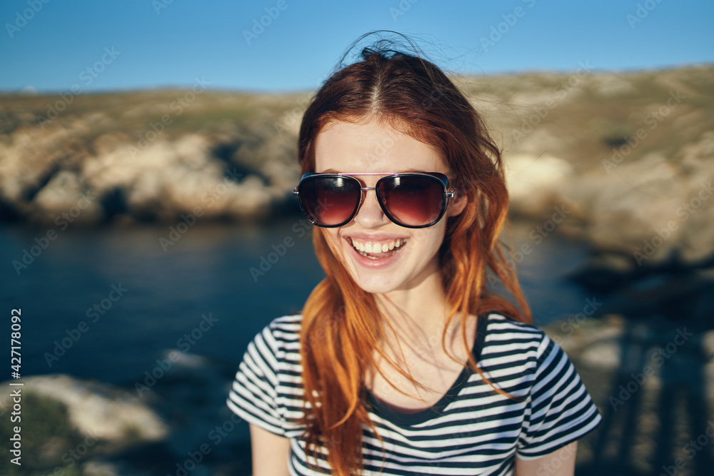 portrait of a happy traveler in a t-shirt and glasses and near the sea in the mountains portrait of a happy traveler in a t-shirt and glasses and near the sea in the mountains