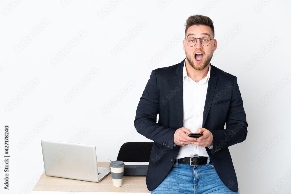Russian man in a office isolated on white background surprised and sending a message Russian man in a office isolated on white background surprised and sending a message