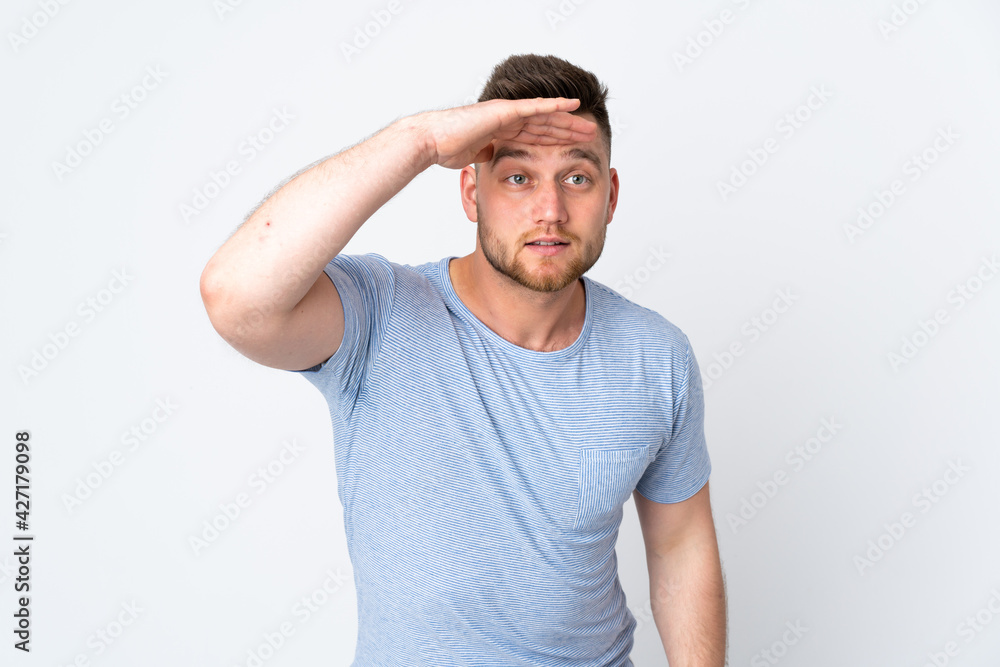 Russian handsome man over isolated background looking far away with hand to look something Russian handsome man over isolated background looking far away with hand to look something