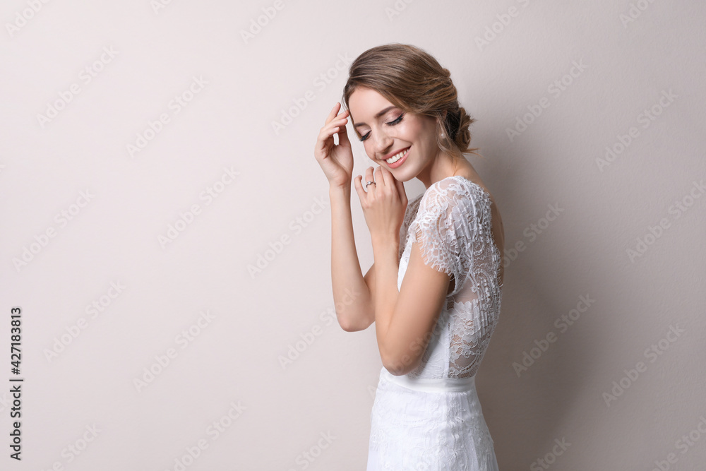 Young bride with elegant wedding hairstyle on beige background. Space for text Young bride with elegant wedding hairstyle on beige background. Space for text