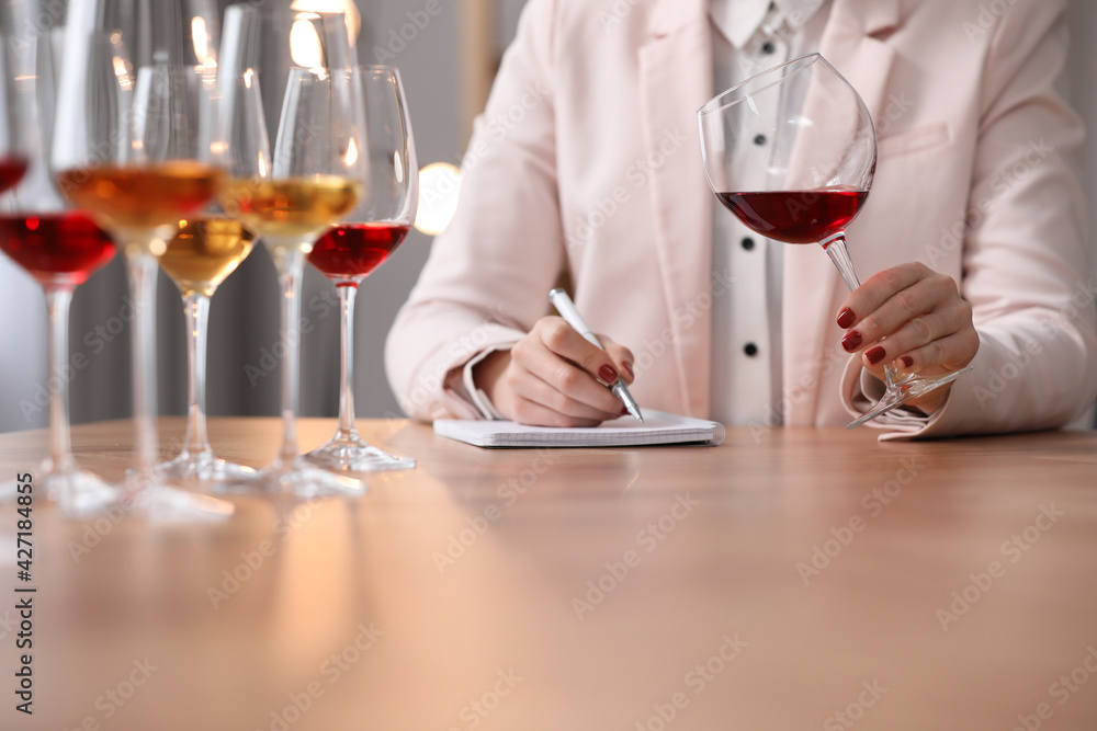 Sommelier tasting different sorts of wine at table indoors, closeup Sommelier tasting different sorts of wine at table indoors, closeup