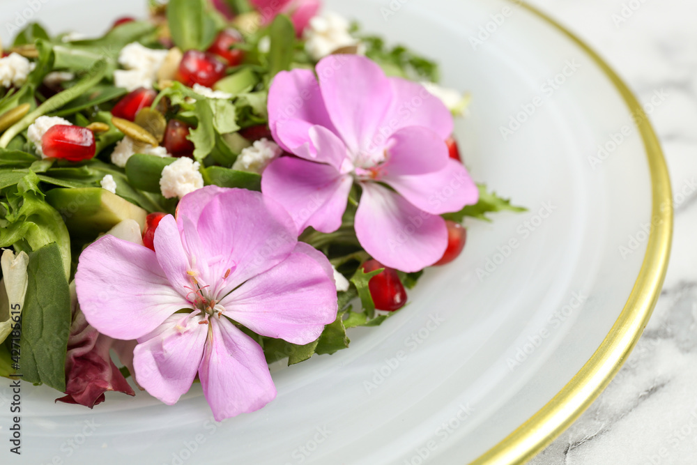 Fresh spring salad with flowers on white marble table, closeup Fresh spring salad with flowers on white marble table, closeup
