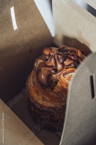 Delicioso cruffin takeaway de chocolate dulce para desayuno con cafe.