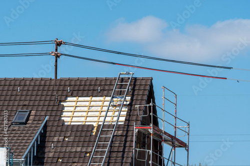 Roofing work with power cable and ladder