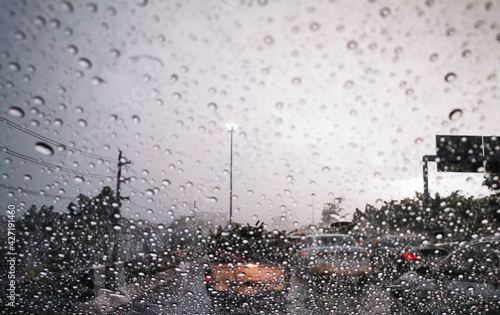 Blur background driving car on metropolis road in trafic jam with raindrop ,rainy season