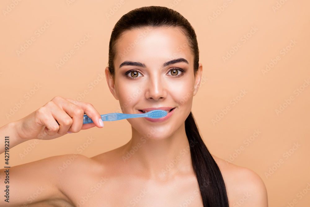 Portrait of nice optimistic brunette lady brush teeth without clothes isolated on pastel beige color background Portrait of nice optimistic brunette lady brush teeth without clothes isolated on pastel beige color background