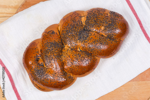 Top view of braided bread with poppy seeds on napkin photo