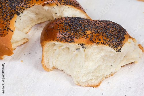 Broken off piece of braided bread with poppy seeds photo