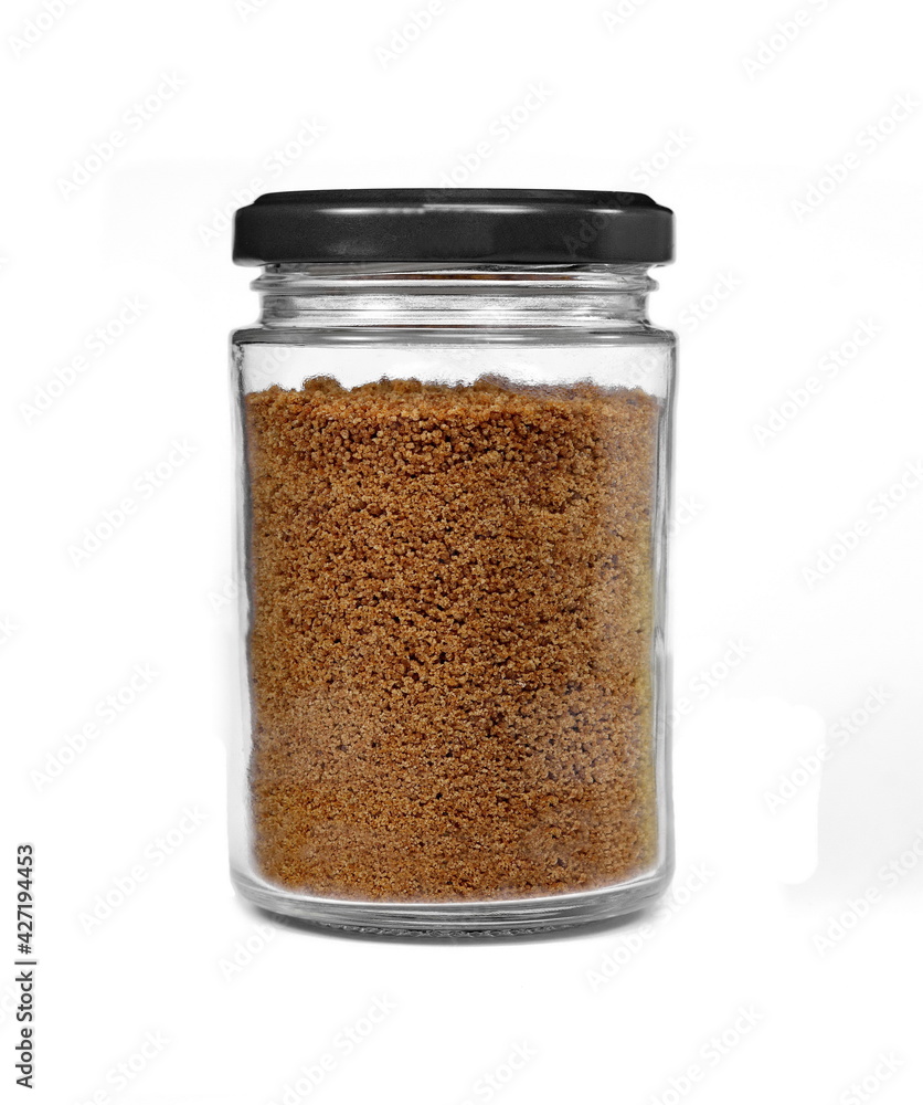 Sweet coconut sugar in a transpatent jar isolated on white background. Sweet coconut sugar in a transpatent jar isolated on white background.