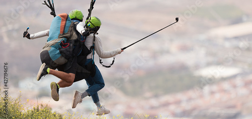 Foto Tandem paraglider running to do a forward launch, launching flight above