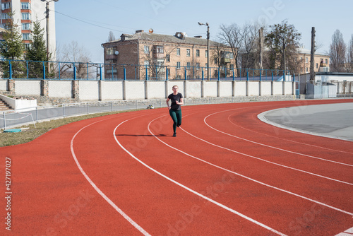 Woman on the track of the stadium. Summer fitness workout.