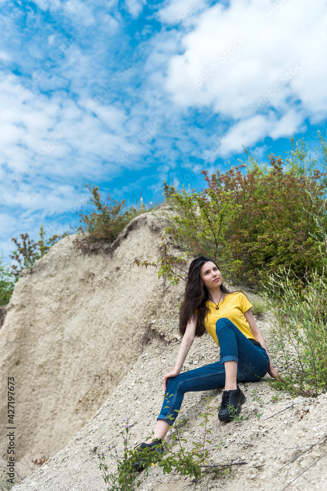 Naklejka premium female model in casual cloth walk in sand quarry