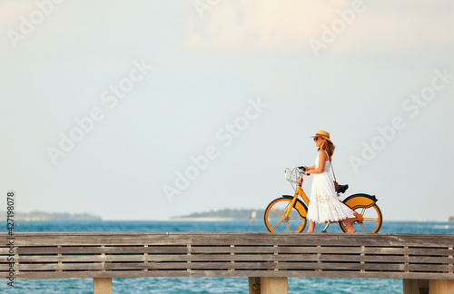 Woman walking with bicycle along promenade photo