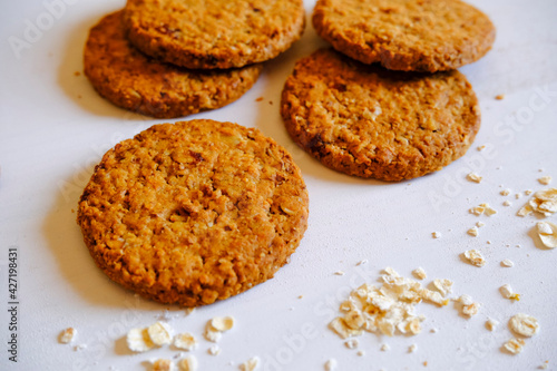 Oatmeal handmade cookies on white background close-up across crumbs. healthy eating. Gluten-free dessert. Sugar-free biscuits. 