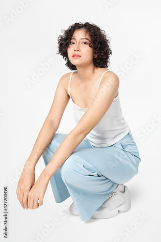 Fototapeta Woman sitting and posing in simple outfit full body
